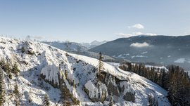 Terenten im Pustertal Schneebedeckte Erdpyramiden in den Bergen unter blauem Himmel