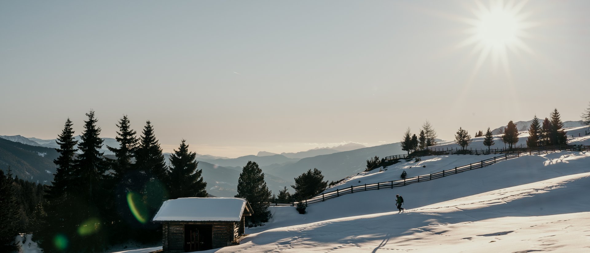 Die Almencard speziell für euch Verschneite Hütte und Wanderer bei sonnigem Wintertag in den Bergen