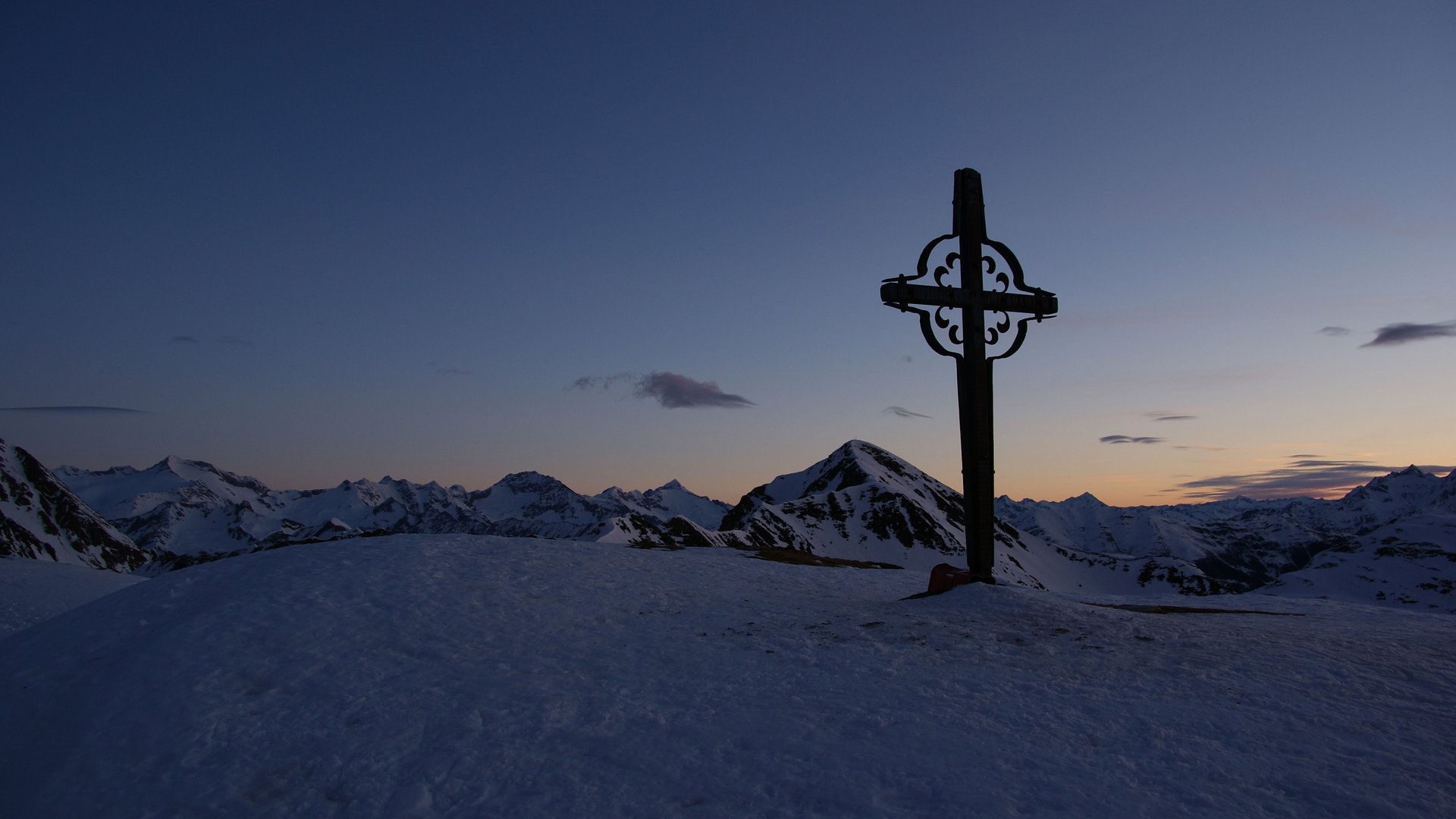 Wandern in Terenten/Pustertal Kreuz auf verschneitem Berggipfel bei Sonnenuntergang in den Alpen