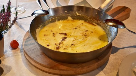 The eco-friendly way to enjoy South Tyrol Bowl with melted cheese on a wooden board