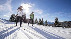 Langlauf auf der Rodenecker-Lüsner Alm Zwei Menschen beim Langlaufen auf verschneiter Strecke im Sonnenschein