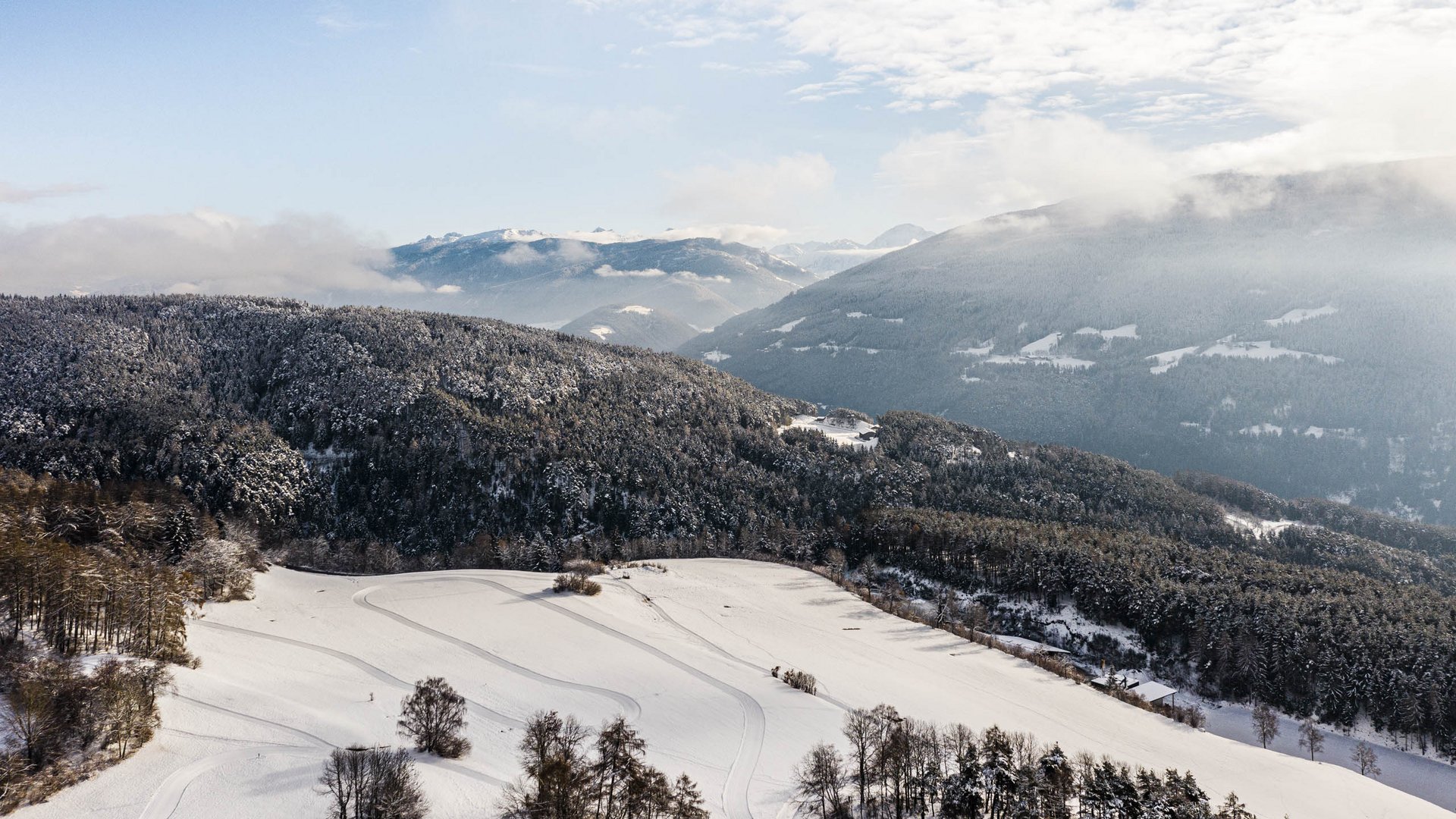 Langlaufen in Terenten Winterlandschap met besneeuwde bergen en bossen onder een blauwe lucht