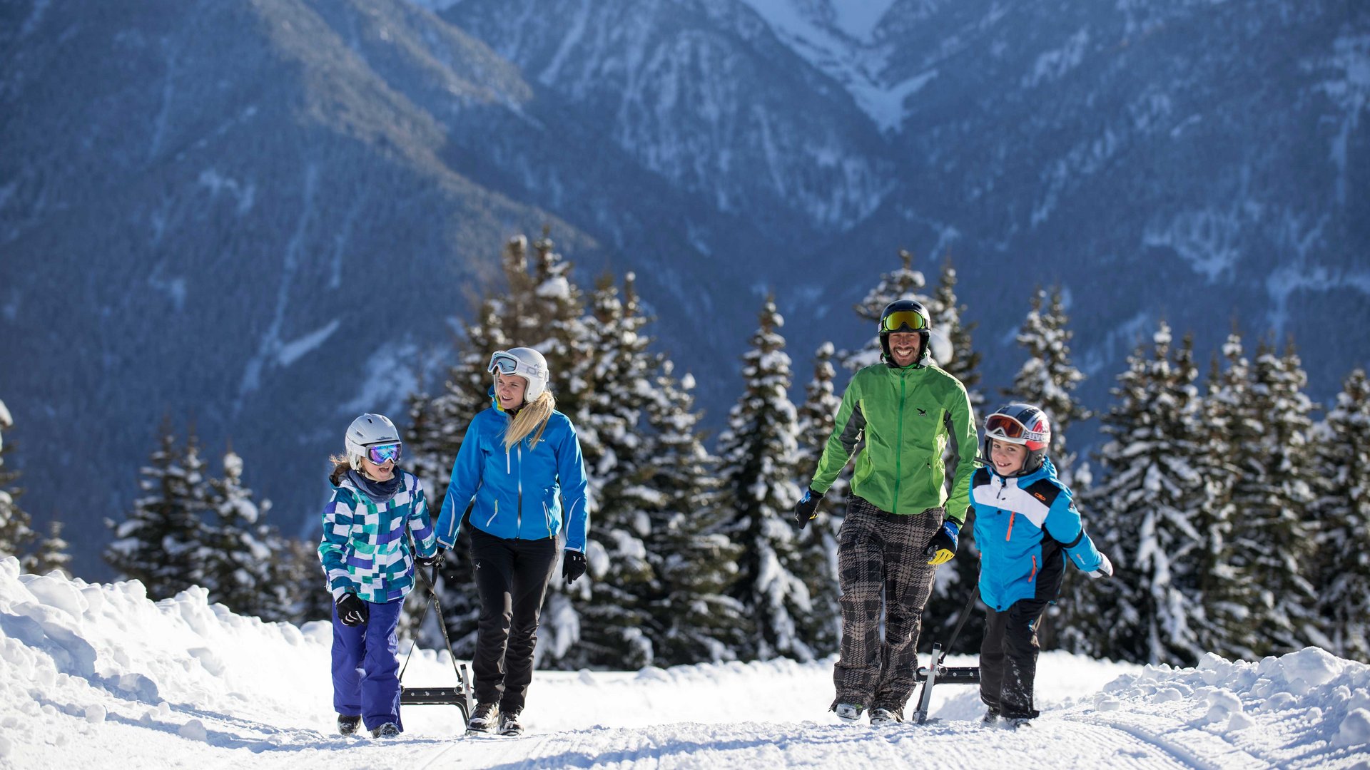 Sáňkování v Terentenu: Nefalšované zimní radovánky Rodina chodí s saněmi v zasněžené horské oblasti