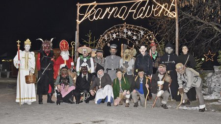 The eco-friendly way to enjoy South Tyrol People in traditional Krampus and Saint Nicholas costumes under lit arch