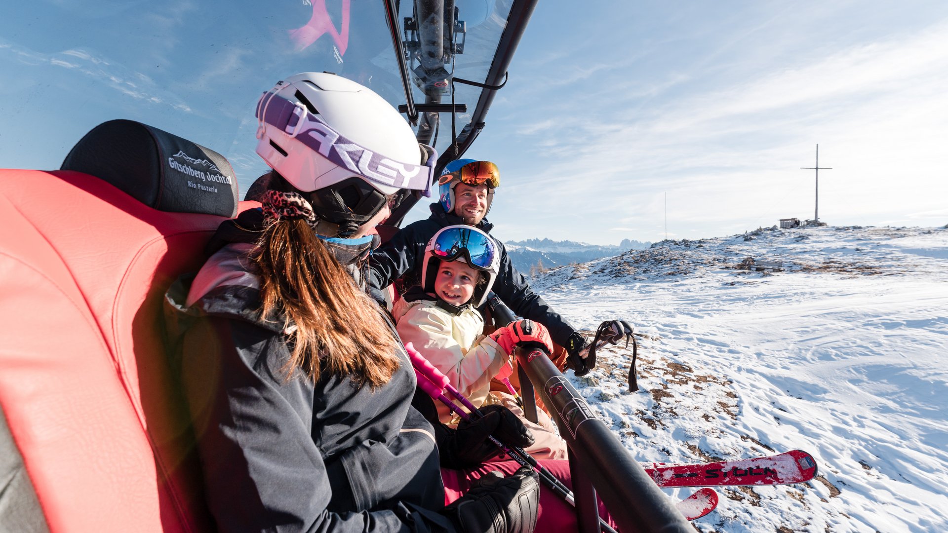 Family ski holidays in South Tyrol Family riding ski lift on sunny snowy mountain