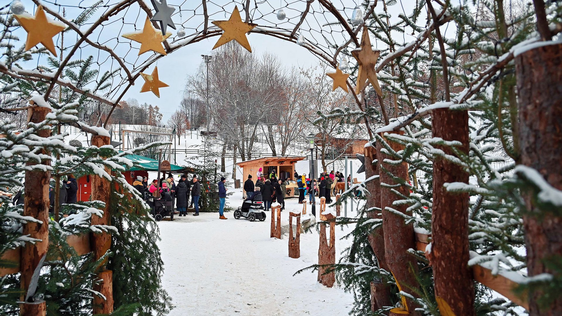 Tearna Advent Winterlicher Markt mit dekorativen Sternen und Menschen im Schnee