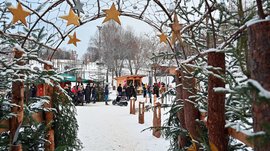 Tearna Advent Winterlicher Markt mit dekorativen Sternen und Menschen im Schnee