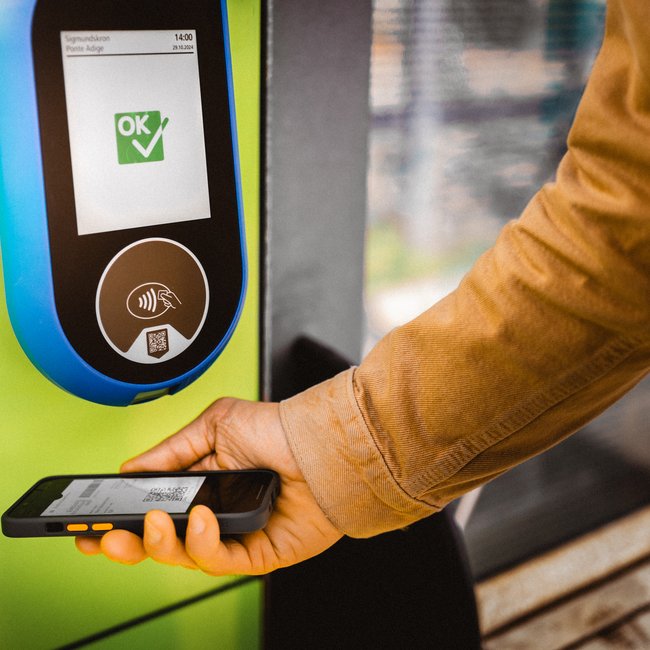 The Almencard: experience South Tyrol like a VIP Person scanning digital ticket code with smartphone at a scanner