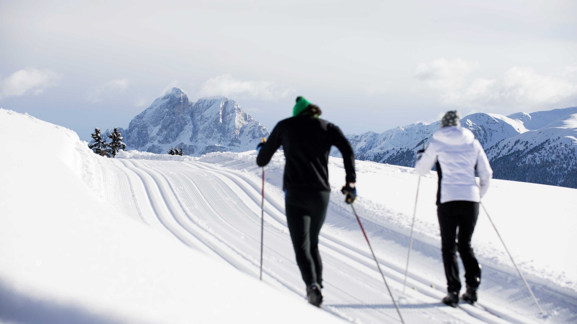 Langlauf auf der Rodenecker-Lüsner Alm Zwei Langläufer auf verschneiter Spur vor Bergen