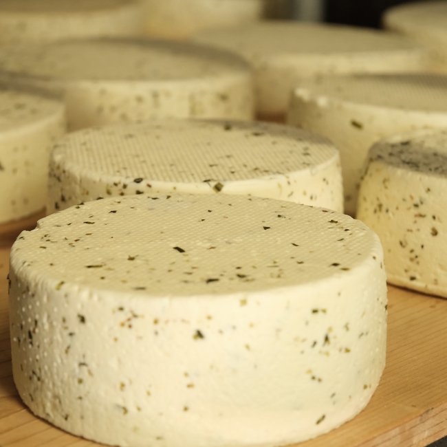 The eco-friendly way to enjoy South Tyrol Round fresh herb cheeses on wooden board in cheese dairy
