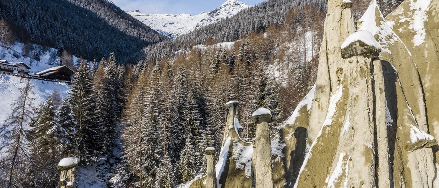 The Gitschberg webcams Snow-covered earth pyramids with forested mountains and blue sky