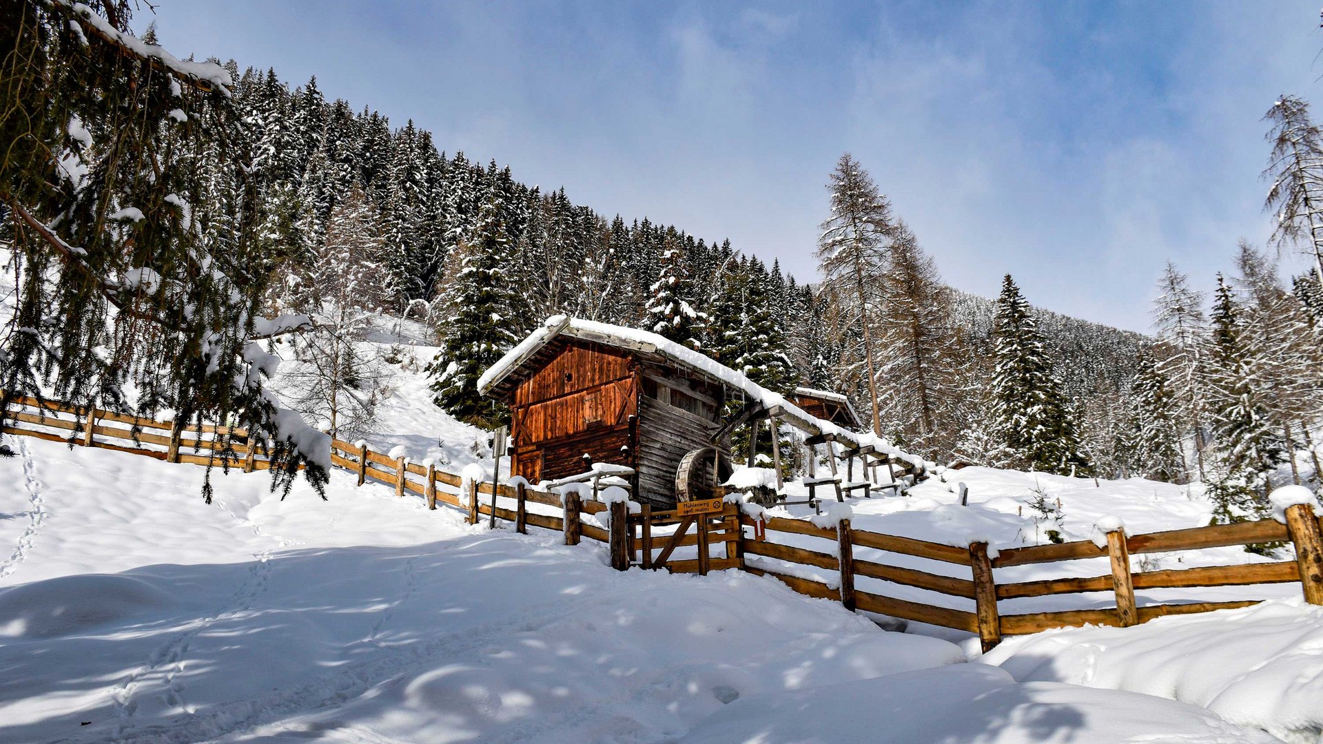 Wandern in Terenten/Pustertal Verschneite Hütte im Winterwald mit Holzzaun