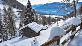 Wandern in Terenten/Pustertal Verschneite Berghütte und Bäume im Winter im Tal