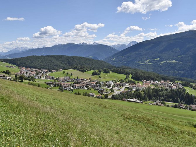 The Alpine hamlet of Spinges View of a village in a green valley with mountains and blue sky
