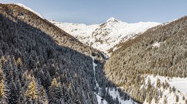 Terenten im Pustertal Verschneite Berge und Tannen im Sonnenlicht