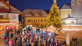Tearna Advent Weihnachtsbaum mit Beleuchtung und Menschen, die eine Feier auf dem Marktplatz beobachten