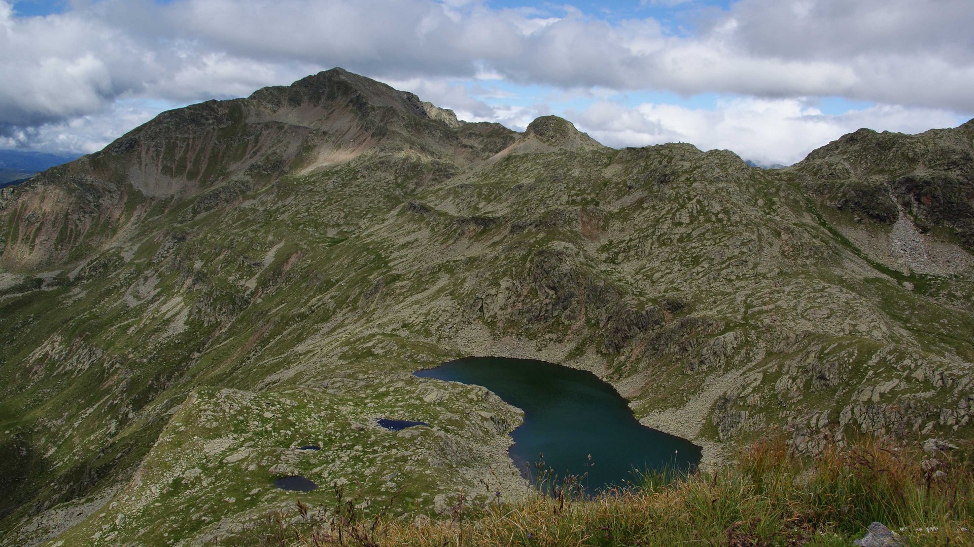 Wandern in Terenten/Pustertal Berglandschaft mit See unter bewölktem Himmel