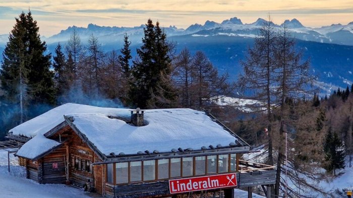 Rund um Meransen: Hütten und Almen Schneebedeckte Hütte Linderalm in den Bergen mit Rauch aus dem Schornstein