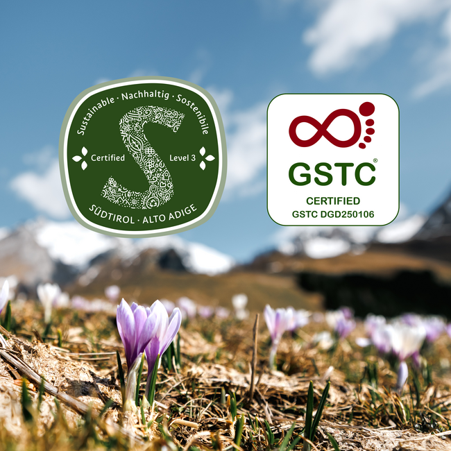 The eco-friendly way to enjoy South Tyrol Sustainability certification logos with flowers in a mountain valley