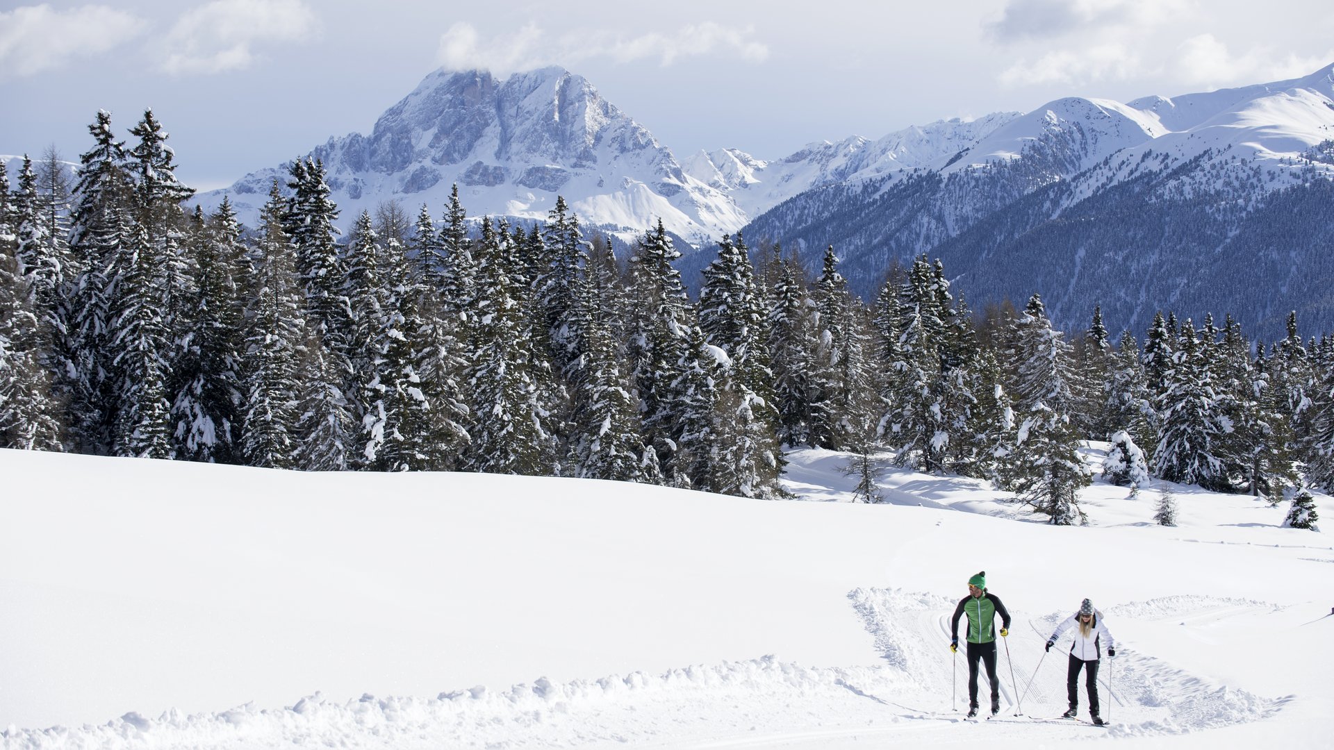 Langlauf auf der Rodenecker-Lüsner Alm Zwei Skilangläufer auf schneebedeckter Route vor Bergen und Wald