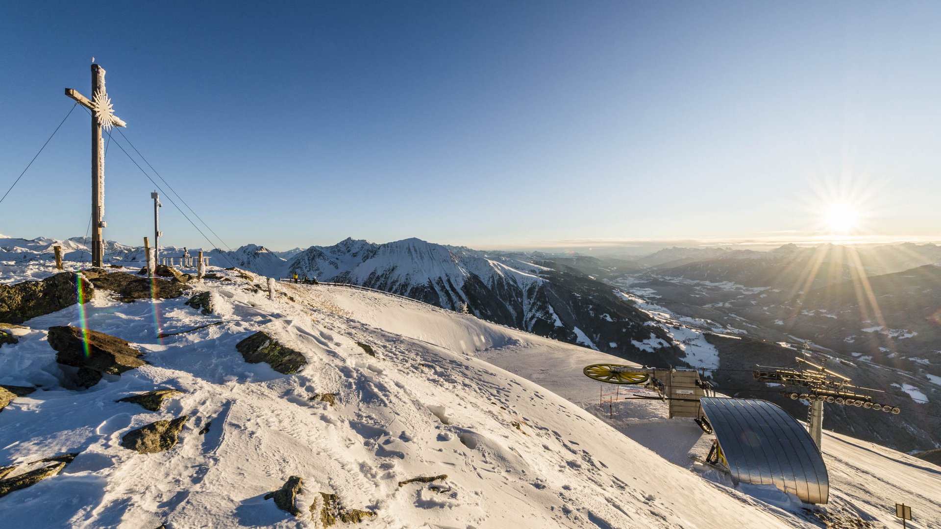 The Gitschberg panoramic platform in Meransen, Italy Sunset on snowy mountain with summit cross and ski lift