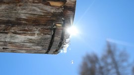 Hiking in Spinges, South Tyrol – no map needed! Ice melting and dripping from wooden beam in bright sunshine