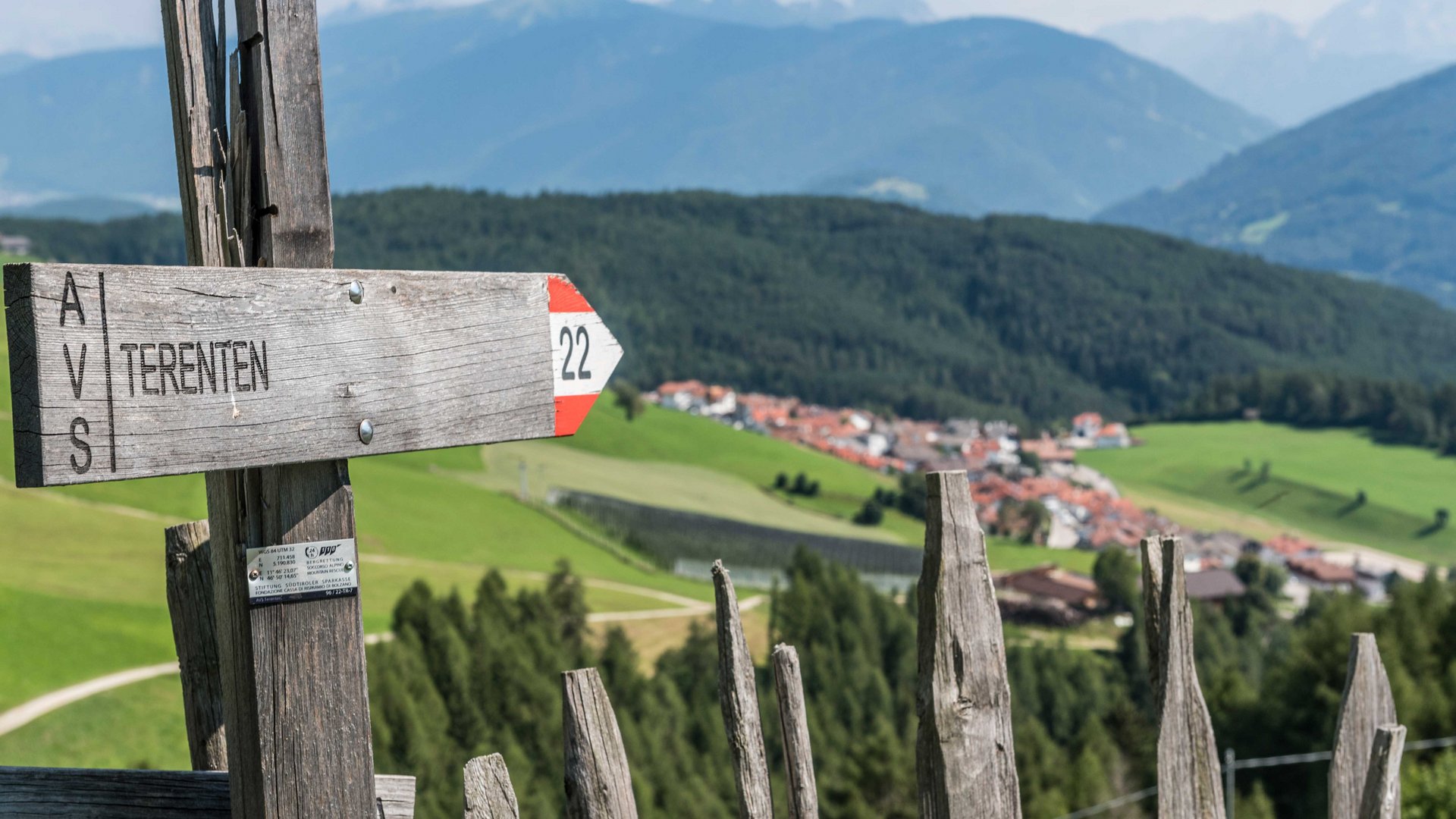 Wandern in Terenten/Pustertal Wegweiser Terenten mit Blick auf grüne Felder und Berge im Hintergrund