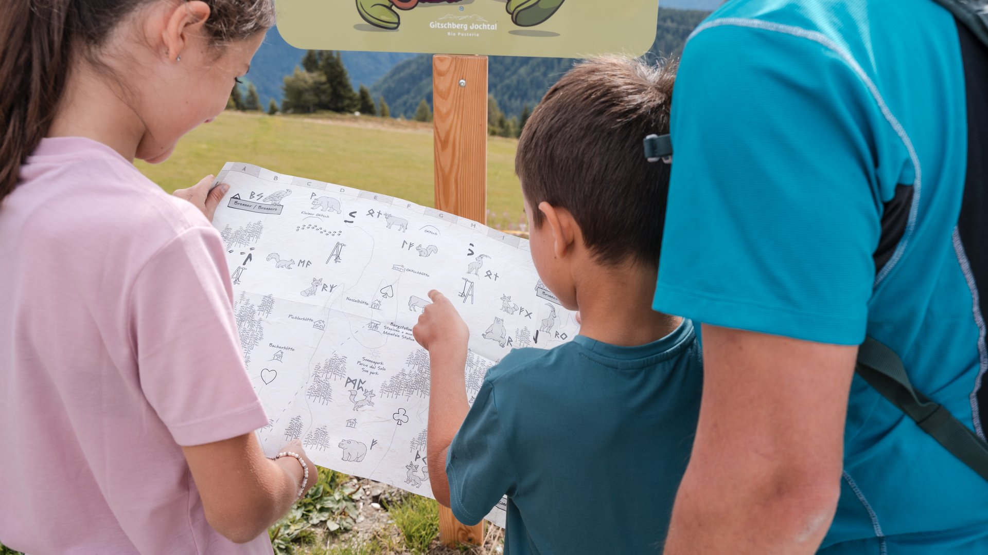 Outdoor Escape on Mt. Gitschberg Family looking at a hiking map in the mountains