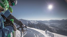 The Gitschberg panoramic platform in Meransen, Italy Skiers reading an information board with sun and mountain view