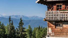 Terenten im Pustertal Holzhaus mit Balkon und Bergblick unter klarem Himmel