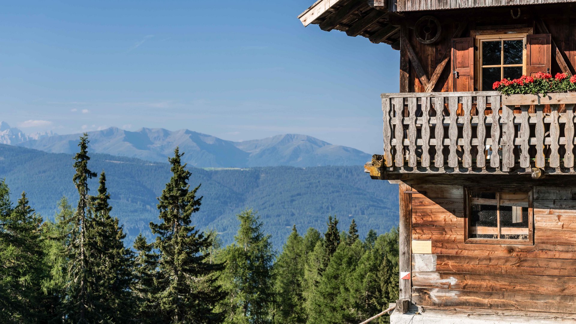 Terenten im Pustertal Holzhaus mit Balkon und Bergblick unter klarem Himmel