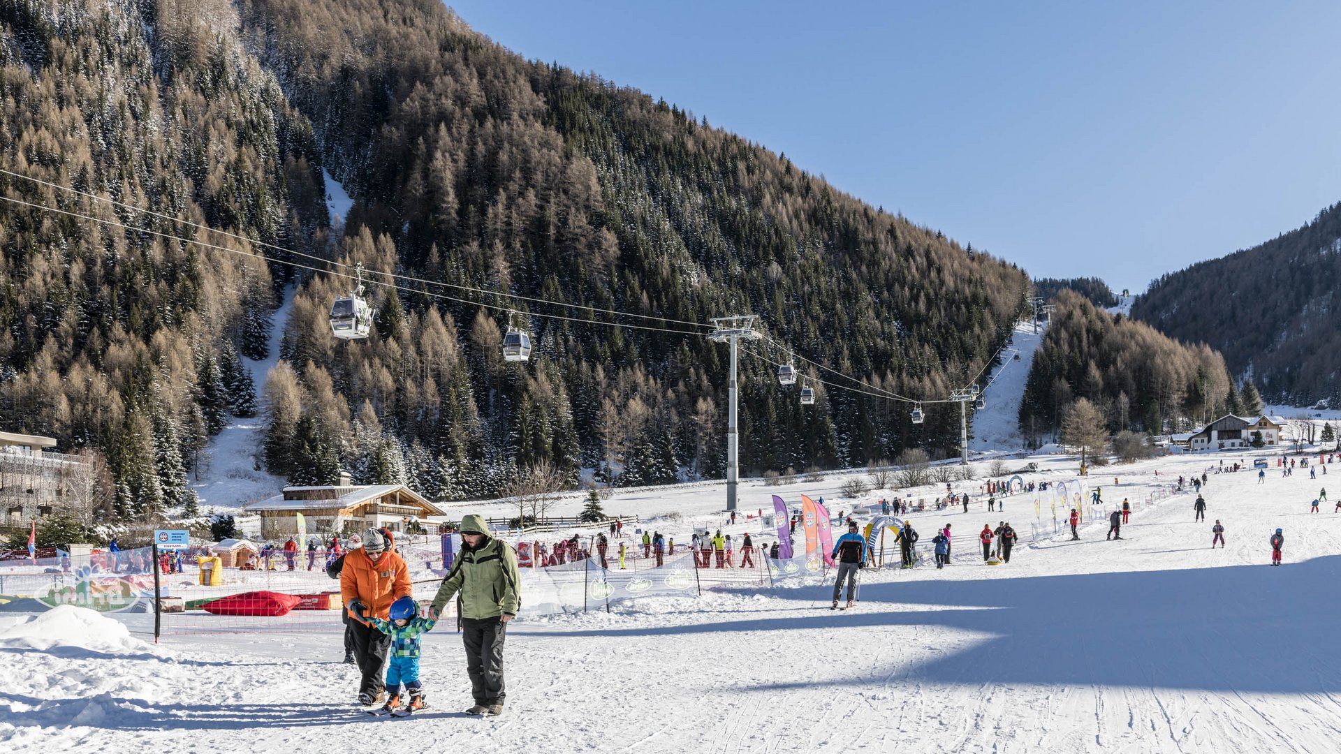 Lyžařská oblast Gitschberg Jochtal Lyžařské středisko s lidmi, lanovkami a zasněženými horami za jasného počasí