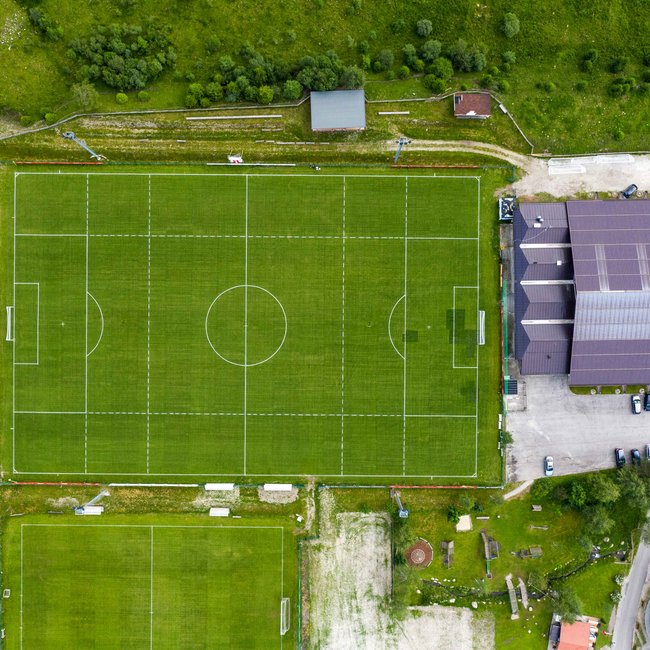Summer holidays in South Tyrol: hiking and more Two football fields can be seen from above. One big and one small. Around the fields is a green area.