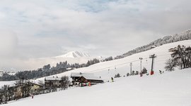 Terenten im Pustertal Skifahrer auf schneebedecktem Hang mit Seilbahn und Alpen im Hintergrund